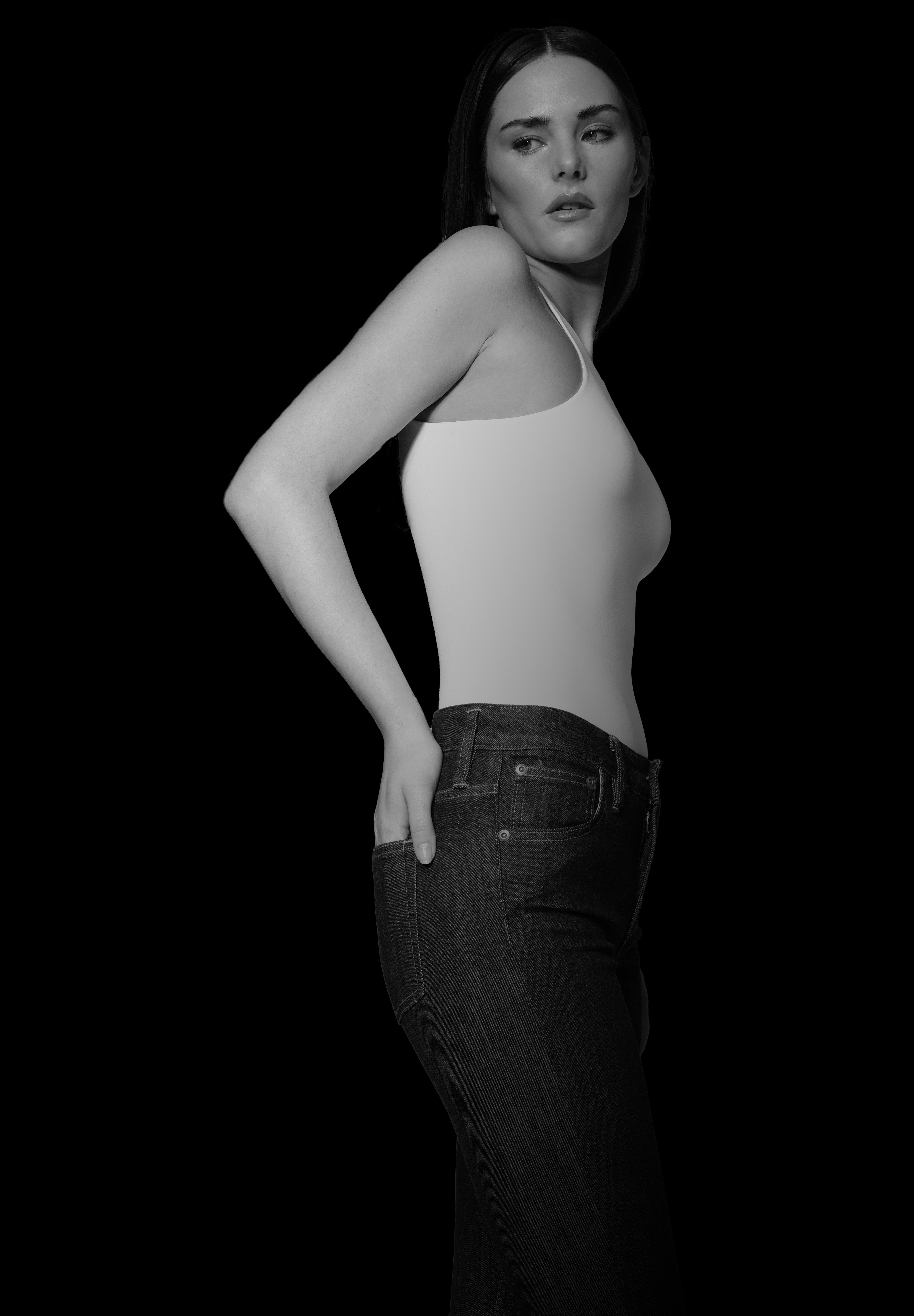 woman in white bodysuit and bootcut jeans