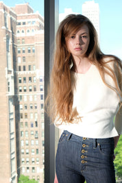 Woman standing in front of a glass window with cityscape background